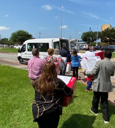 CHRISTUS employees load fans into a truck