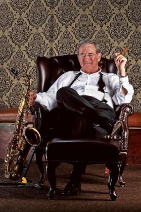 Jimmy Simmons sits in a chair with his instrument.
