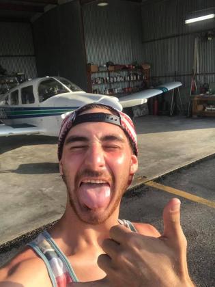 Photo of Adam Meaux in front of an airplane 