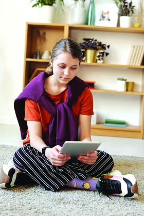 A teenager uses a tablet device 