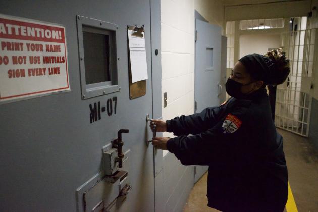 Officer Bell secures the door to a maximum-security cell at the Jefferson County Correctional Facility on Jan. 25. Two guards monitor this hallway at all times.