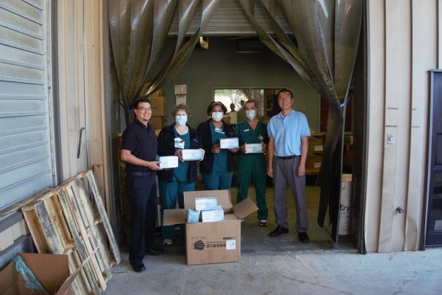 Moses Ceciliano, far left, and Mike, far right, of Great China Restaurant pose with 1,000 medical masks they donated to a CHRISTUS warehouse in Beaumont on April 13.